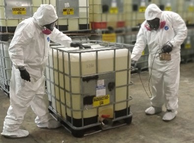 Men in hazard suits handling waste